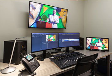 video editing bay with hardware on desk.